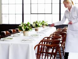 MS smiling waitress setting banquet table for dinner party in loft Stock Footage