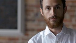 Young bartender stares at camera in restaurant dining room Stock Footage