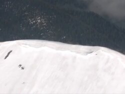 AERIAL WS POV View of grass field on mountain behind snow mountains / Montana, United States Stock Footage