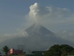 Mayon volcano spews ash and steam over city on clear day, Philippines, Dec 2009 Stock Footage