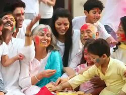 Family celebrating holi festival in the lawn  Stock Footage