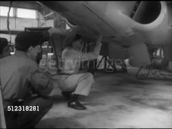 1952: FRENCH MOROCCO: MILITARY: French soldiers in hangar w/ American USAF officer under parked Lockheed T-33 'Shooting Star' jet trainer aircraft (TR-431), men watching landing gear retracting, VS Soldiers listening, watching, taking instruction note. Instructional Video