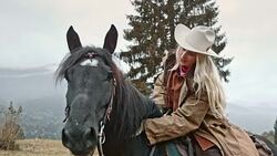 SLO MO Portrait of cowgirl stroking horse's neck Stock Footage
