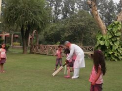 Senior man playing cricket with his grandchildren in holi festival  Stock Footage