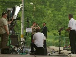 WS PAN Shot of television news crews preparating for G8 meeting and man on electric chariot / Hokkaido Toyako, Japan Stock Footage