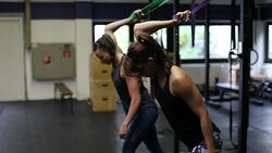 Athletes pulling resistance bands in gym Stock Footage
