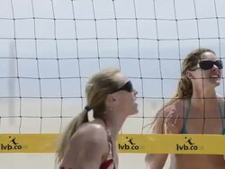 CU of female beach volleyball players spiking and blocking at the net. Stock Footage