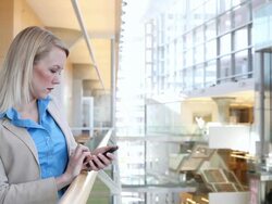 MS Well dressed business woman using cellular device inside office building during day / Minneapolis, Minnesota, United States Stock Footage