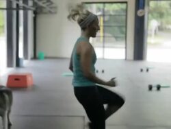 Camera tracks with Carly as she performs high-knee run Stock Footage