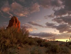 Dramatic rock formations in desert at sunset with beautiful sky - pan Stock Footage