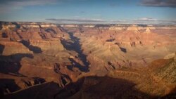 Clouds cast shadows on the Grand Canyon at golden hour. Stock Footage