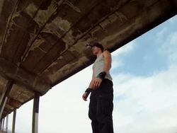 A man does a parkour freerunning backflip under a pier on the beach. - Slow Motion - Model Released - HD Stock Footage