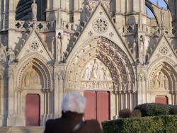Old woman sitting in front of a church Stock Footage