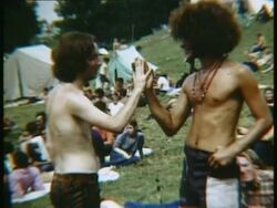 1969 MS ZO Two men standing in field pressing their hands together at Woodstock music festival/ Bethel, New York, USA Stock Footage