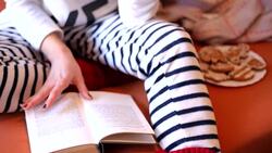 Girl in bed  reading a book Stock Footage