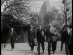 B/W Salvador Dali with easel walking with others at zoo Stock Footage