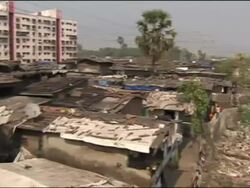 Trains past delapidated apartment blocks of Mumbai Stock Footage