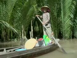 MS Woman paddling canoe along a backwater channel of the Mekong Delta / Vietnam Stock Footage