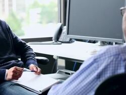 CU PAN R/F Businessman and mature businessman sitting in discussion in office workstation/Washington, USA Stock Footage