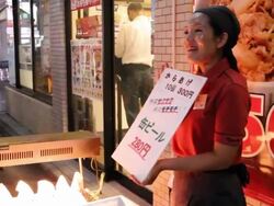 Female Japanese vendor calling out featuring food she's selling Stock Footage