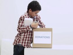 Boy putting food in donation box Stock Footage