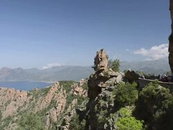 WS View of Cars drive on the road through the fantastic rock landscape of the Calanche of Piana, UNESCO World Heritage Site / Gulf of Porto, Corsica, France Stock Footage
