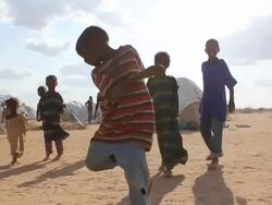 Kids playing with cloth ball in refugee camp Stock Footage