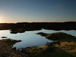 WS PAN Sunset over reflective lake surrounded by volcanic rock / Reykjavik, Borgarfjaroarsysla, Iceland Stock Footage