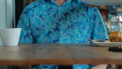 Happy young man eating delicious cake in cafe Stock Footage
