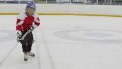 MS Young hockey player skating up to camera on ice rink giving victory sign Stock Footage