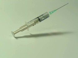 High speed Syringe falls on to surface, white background Stock Footage