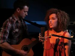 Female singing and male playing guitar in recording studio Stock Footage