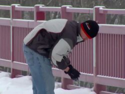 MS PAN Man picking up snow chunk and throwing it over railing / Minneapolis, Minnesota, United States Stock Footage