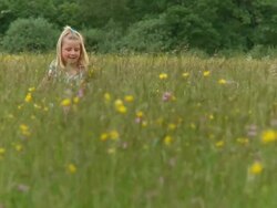 CRANE: Little girl picking flowers Stock Footage