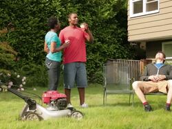MS PAN Man pushing lawn mower and resting with wife and friend in backyard / Portland, Oregon, United States Stock Footage