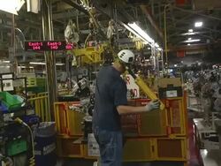 MS Worker using chain hoist to move an engine in an auto assembly plant / Princeton, Indiana, United States Stock Footage