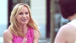 Blonde woman talking to her brunette friend over coffee outside Stock Footage