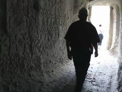 Geghard monastery, tourists walking out from a church Stock Footage