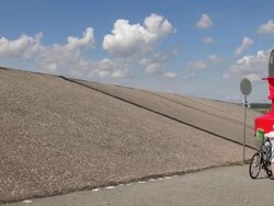MS Shot of dike at eidersperrwerk and two lady walking with bicycle, Dithmarschen, North Sea / Tonning, Schleswig Holstein, Germany Stock Footage