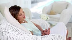Woman using cell phone in wicker chair Stock Footage