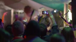Young man takes video of rocking band with smartphone at outdoor music festival Stock Footage