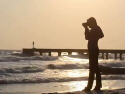 Woman taking photograph on the beach. Stock Footage