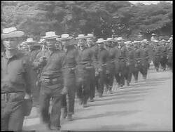 B/W 1962 lines of soldiers in uniforms + hats marching past camera / Cuban Missile Crisis Stock Footage