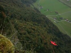 Wing suit flier jumps from cliff and soars above valley below Stock Footage