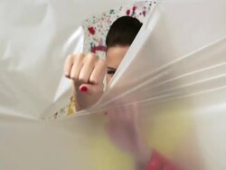 Young woman punching through plastic sheet, slow motion Stock Footage