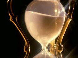 close up tilt down hourglass with sand flowing Stock Footage