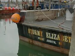Professional fishing boats tied up at dock in harbor - pan from one boat to another Stock Footage