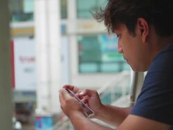Asian male use smartphone on overpass Stock Footage