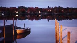 Time-lapse at lake village in Maine, USA with boats and colorful trees reflecting on water Stock Footage