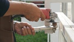 Steel Technician Sawing Steel on Fence for Repair and maintenance House , UHD format Stock Footage